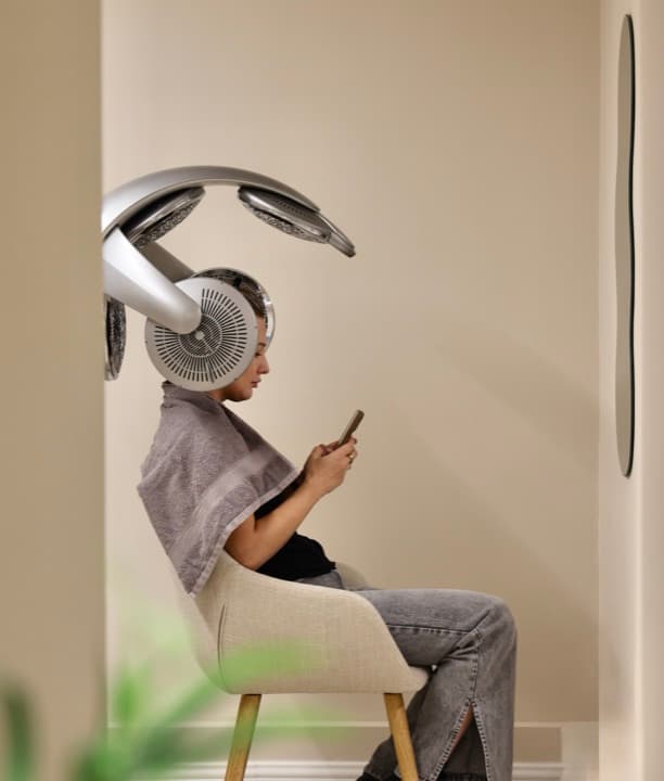 Clientă sub un aparat modern de coafat, într-un salon de beauty